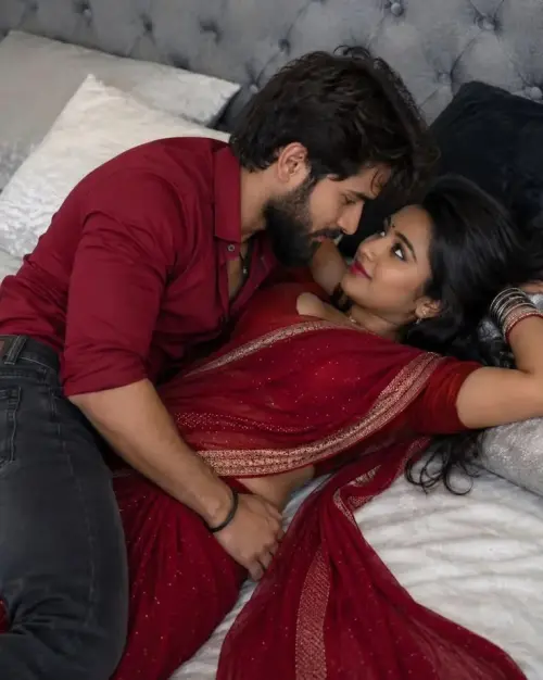 Romantic Indoor Portrait of Indian Couple on Bed in Maroon Attire — AI Photo Editing Prompt on Faymas