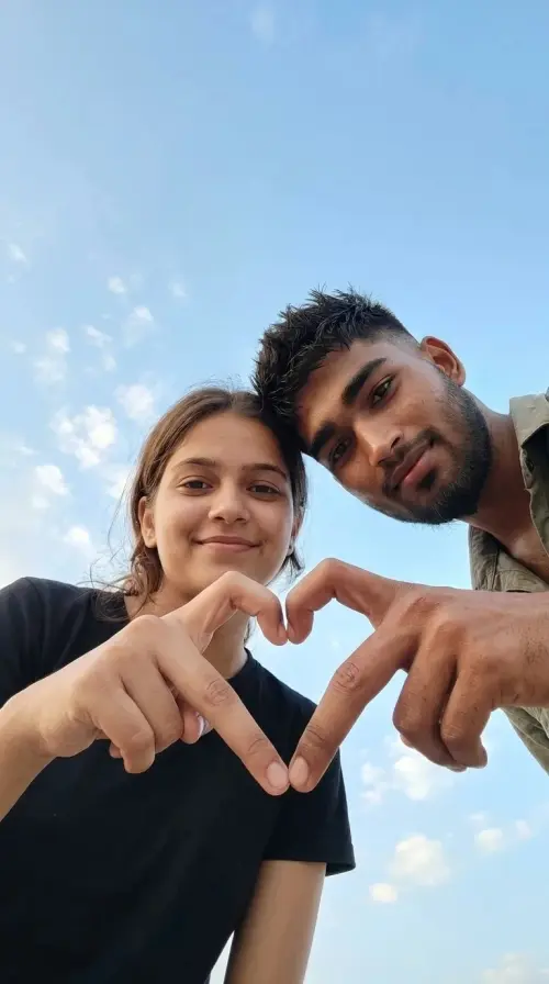 Romantic Couple Low-Angle Hand-Heart Gesture Portrait Under Blue Sky Prompt — AI Photo Editing Prompt on Faymas