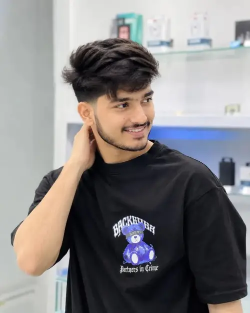 Candid Sunlit Salon Portrait of Smiling Young South Asian Man with Textured Drop Fade Hair and Goatee Touching Nape in " — AI Photo Editing Prompt on Faymas